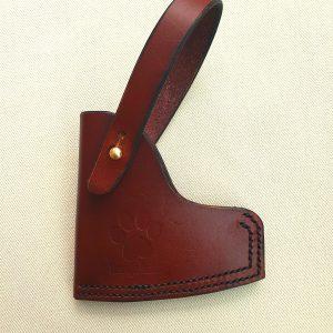 Brown axe sheath with brass stud on white back ground